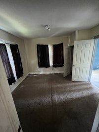 an empty room with carpet and a door