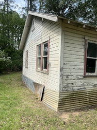 an old house sitting in the middle of the woods