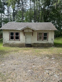 a small house sitting in the middle of a wooded area