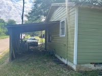 a green house with a car parked in front of it